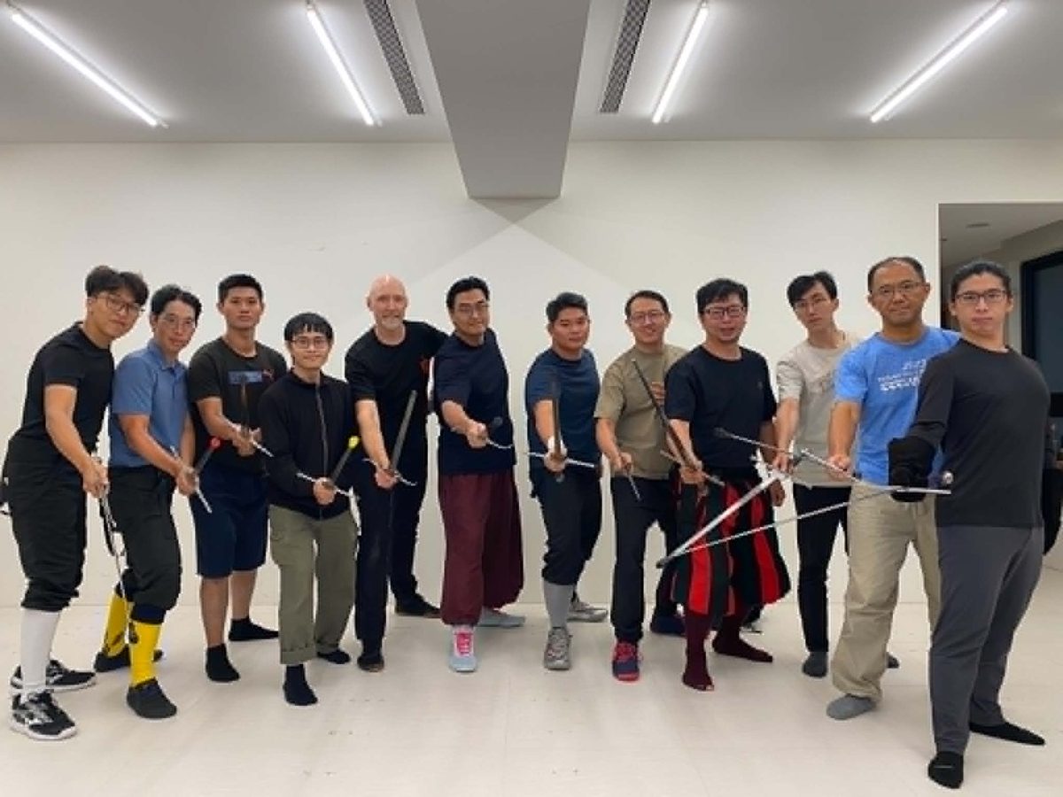 Devon Boorman with the group from the Duello Armizare instructor intensive in New Taipei City, all holding their rapiers out toward the camera