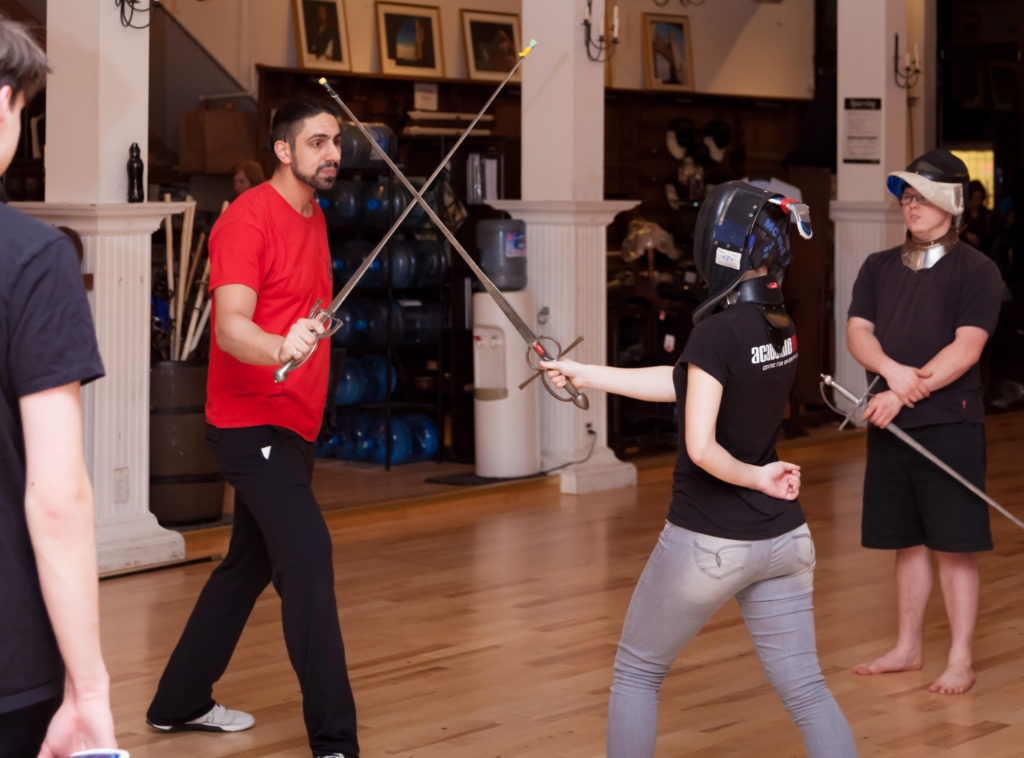 Instructor and student with sideswords. Other students observing.